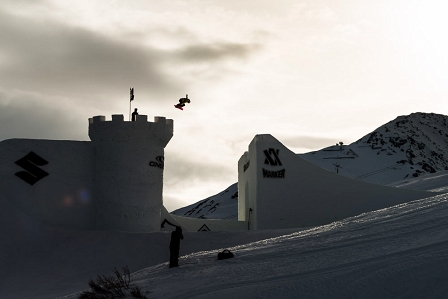 Snowboarderin springt über eine Schneeburg